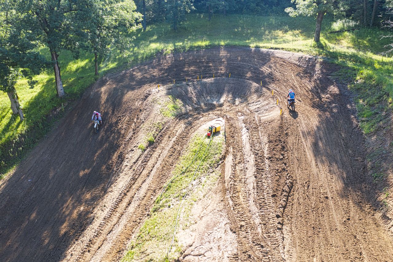 Home Dynamic aerial shot of a motocross race track in Millville, capturing riders in action.